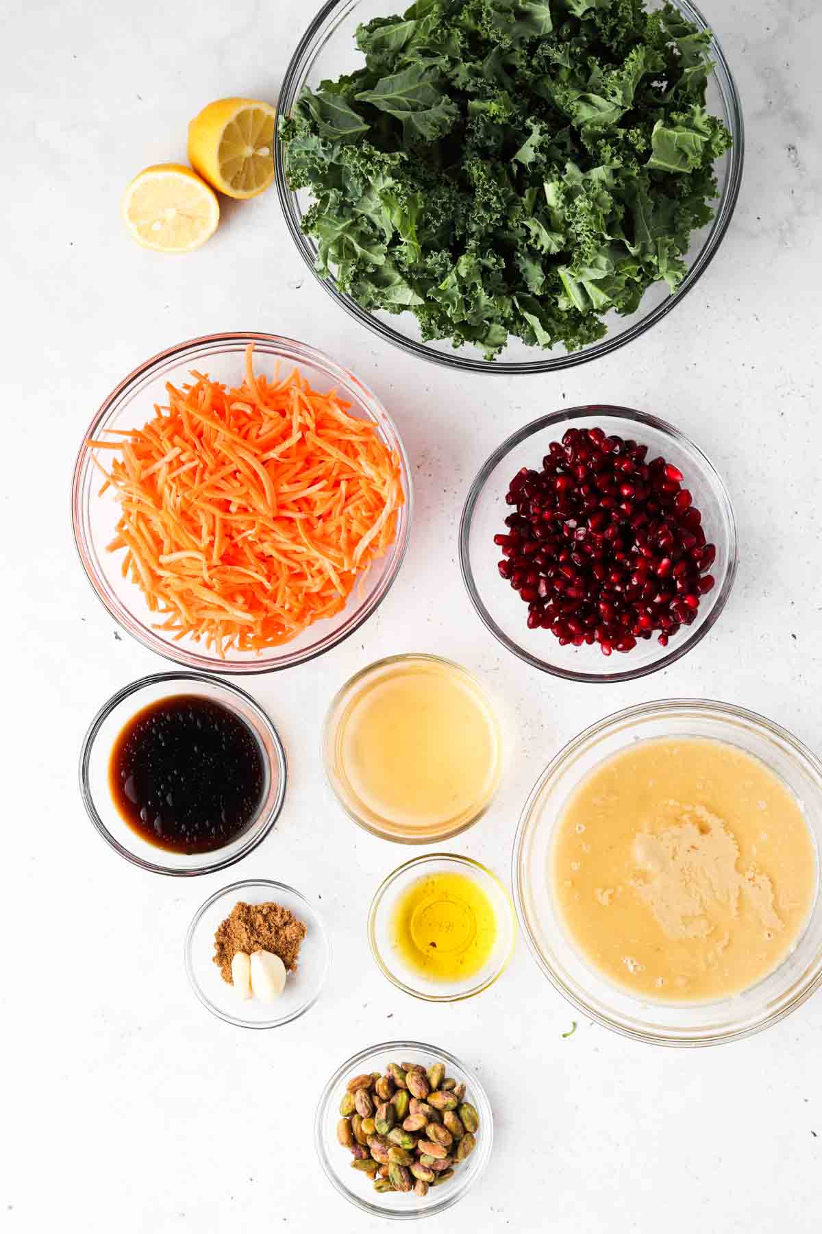 kale salad ingredients laid out in bowls