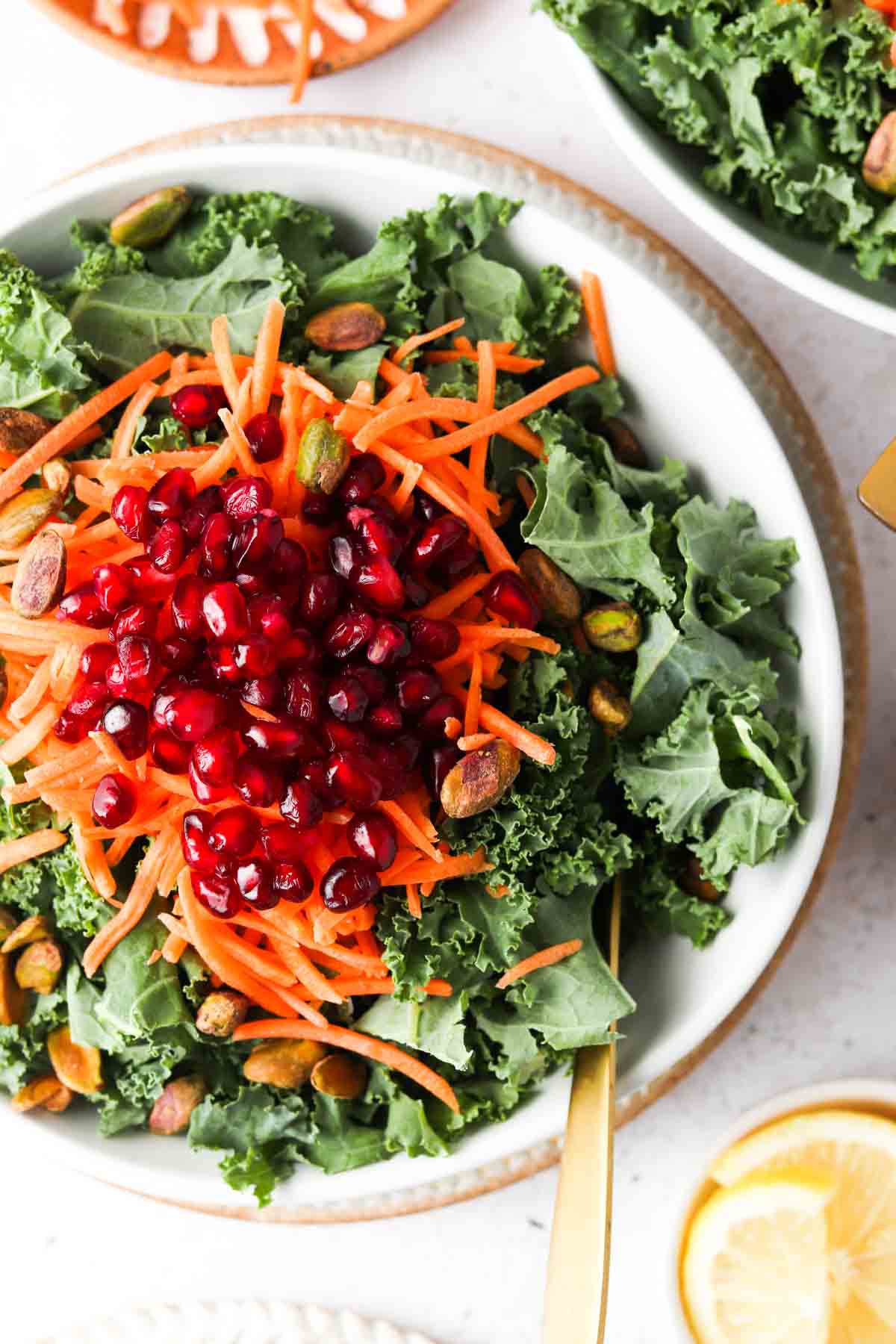  salad in a bowl with pomegranate and lemons