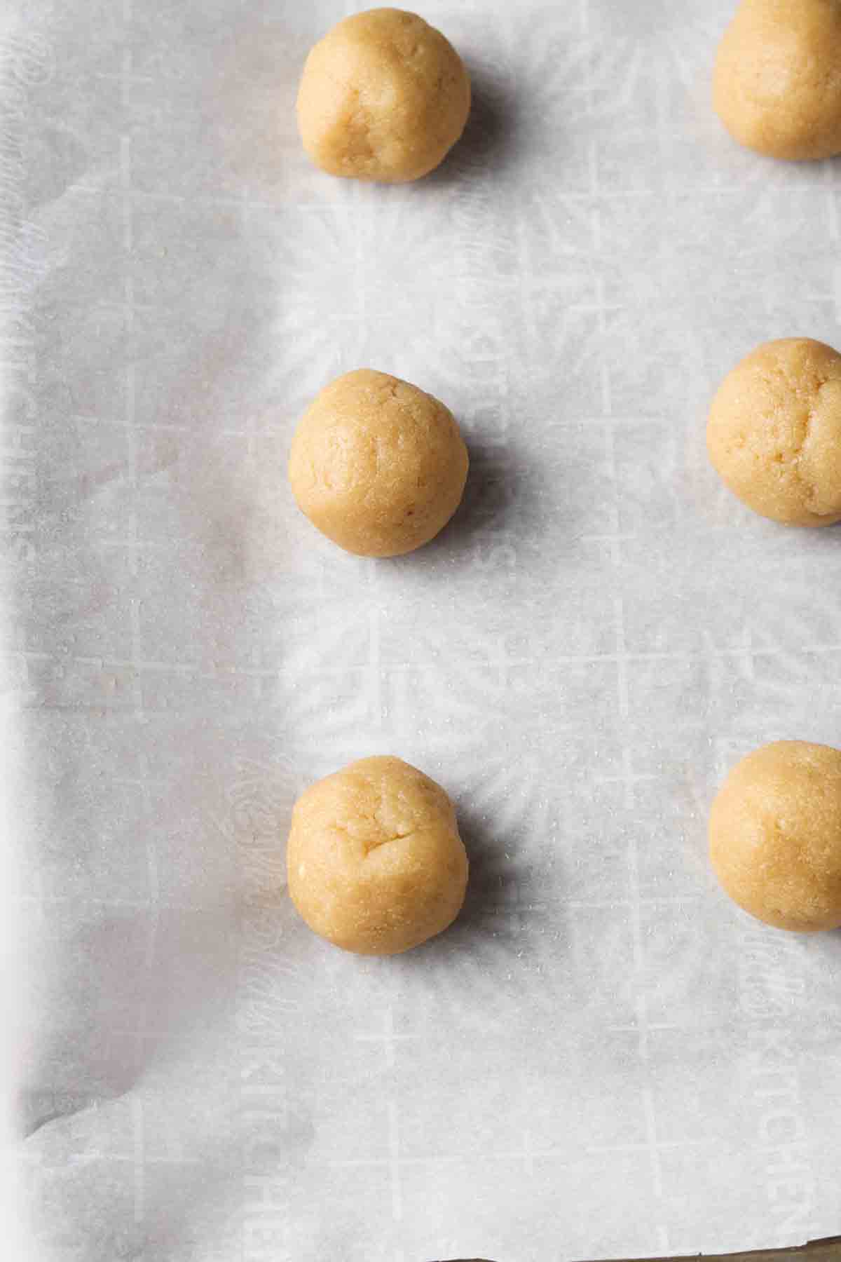 Rolled cake pops on a baking sheet with wax paper. 