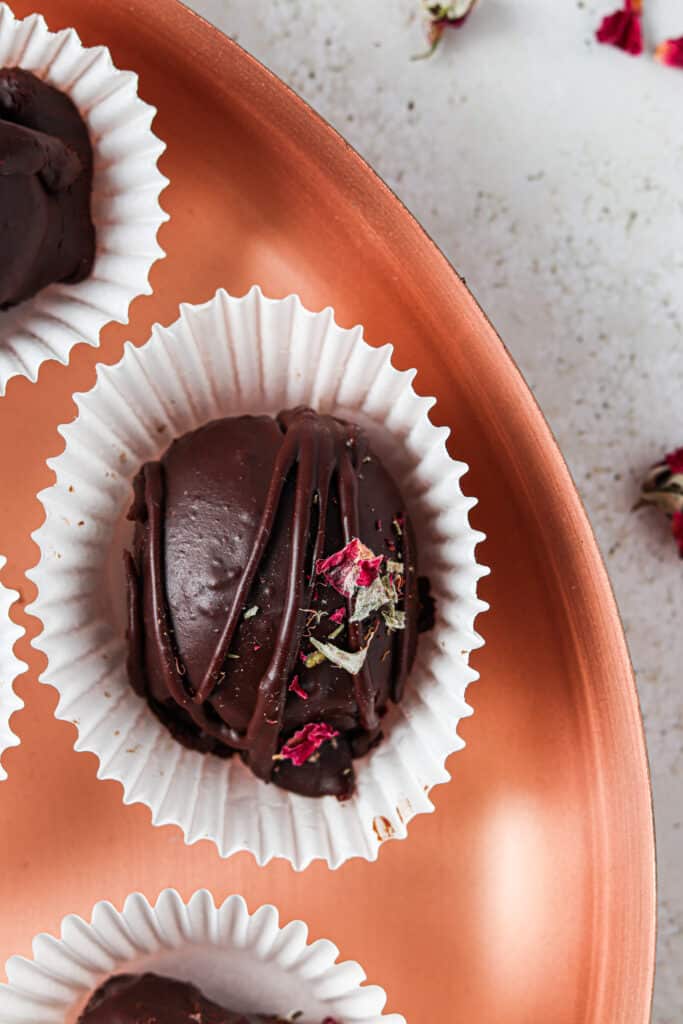 dairy free chocolate truffles on a gold tray with rose petals