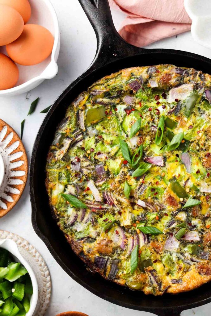 egg frittata in a cast iron pan with fresh pepper on top