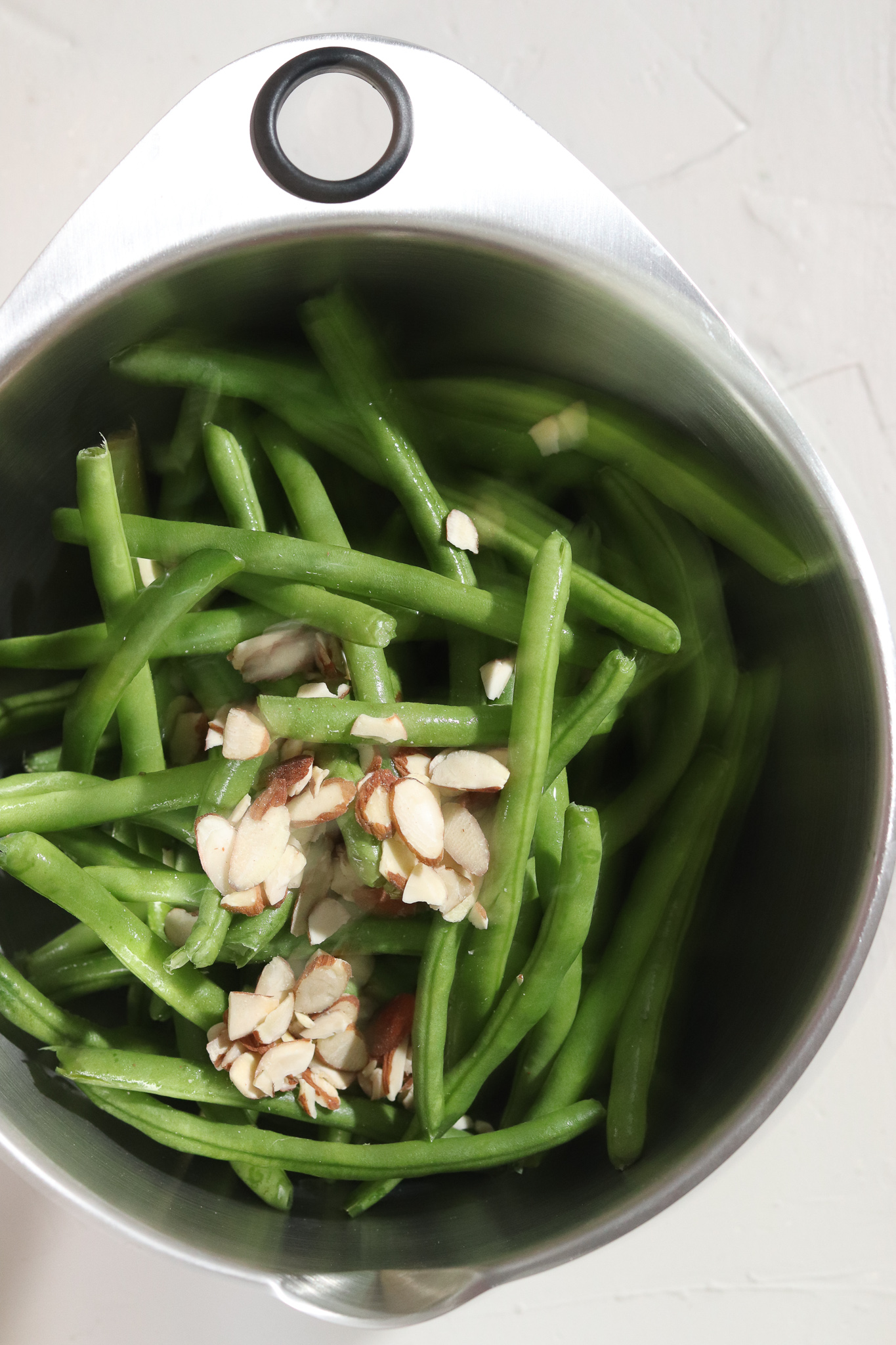 Air fried green bean ingredients in a silver mixing bowl.