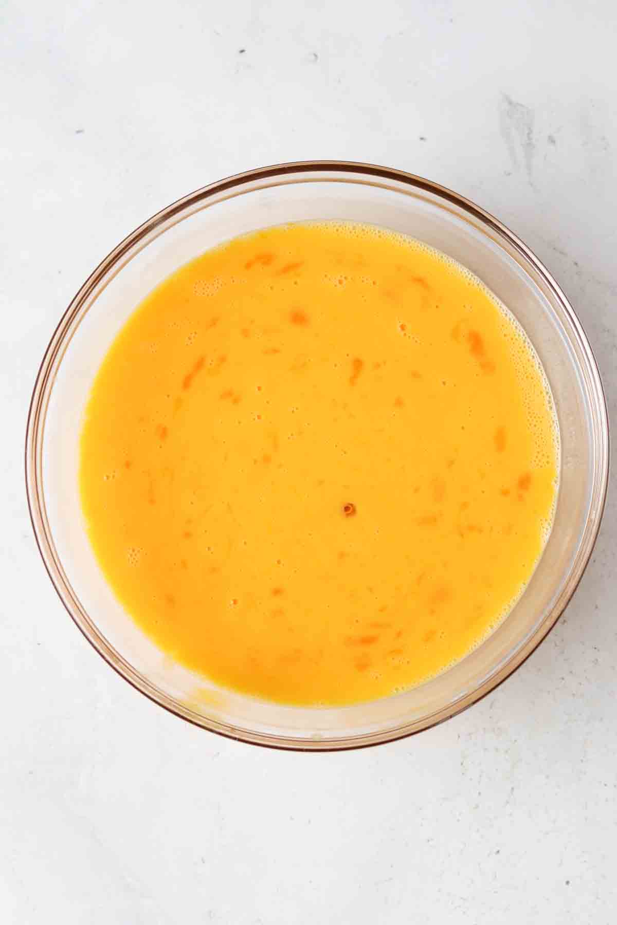 Cracked eggs in a large glass bowl.