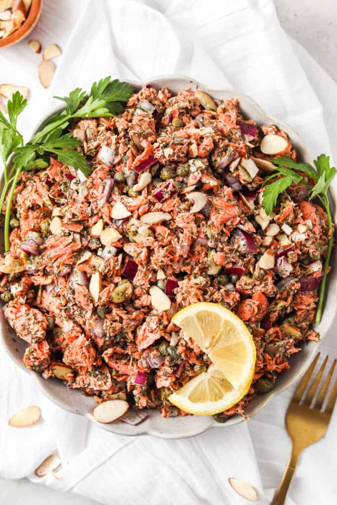 close up overhead shot of shredded lemon dill salmon salad in a scalloped bowl