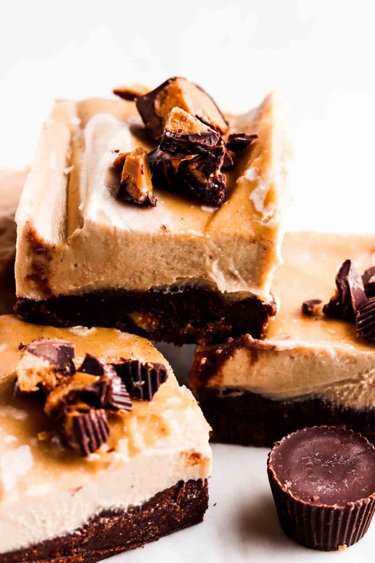 Stacked up cheesecake bars on a plate.