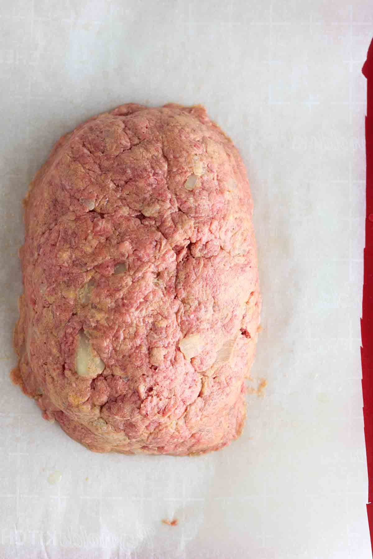 Meatloaf formed on a baking sheet.