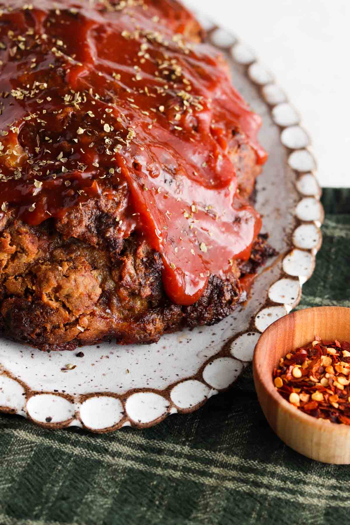 Meatloaf on a platter with ketchup glaze drizzled on top.