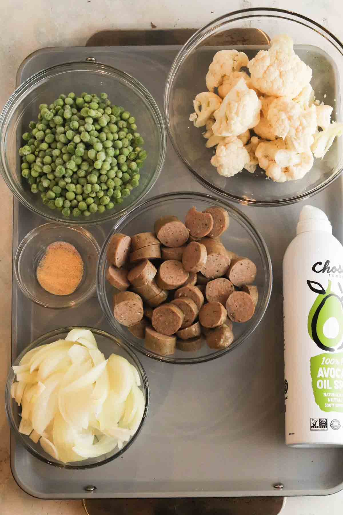Recipe ingredients in glass bowls on a sheet pan.
