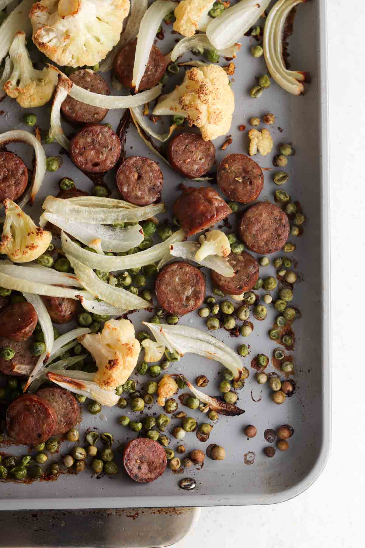 Roasted sausage and vegetables on a sheet pan.