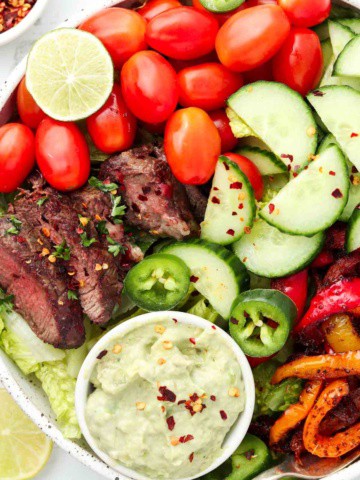 steak salad over greens with peppers and avocado cream dressing