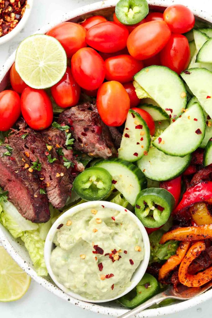 steak salad over greens with peppers and avocado cream dressing