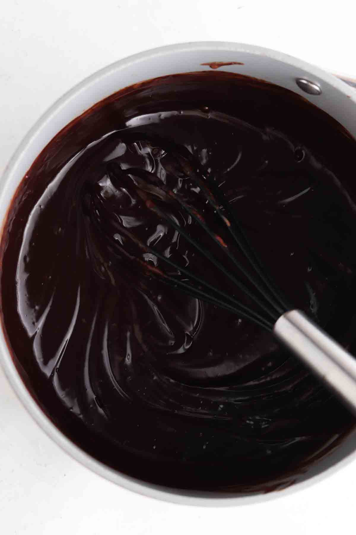 Chocolate and coconut milk whisked together in a pan.