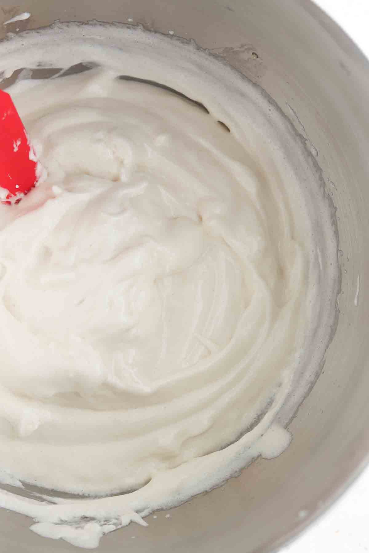 Homemade marshmallow fluff in a mixer bowl.