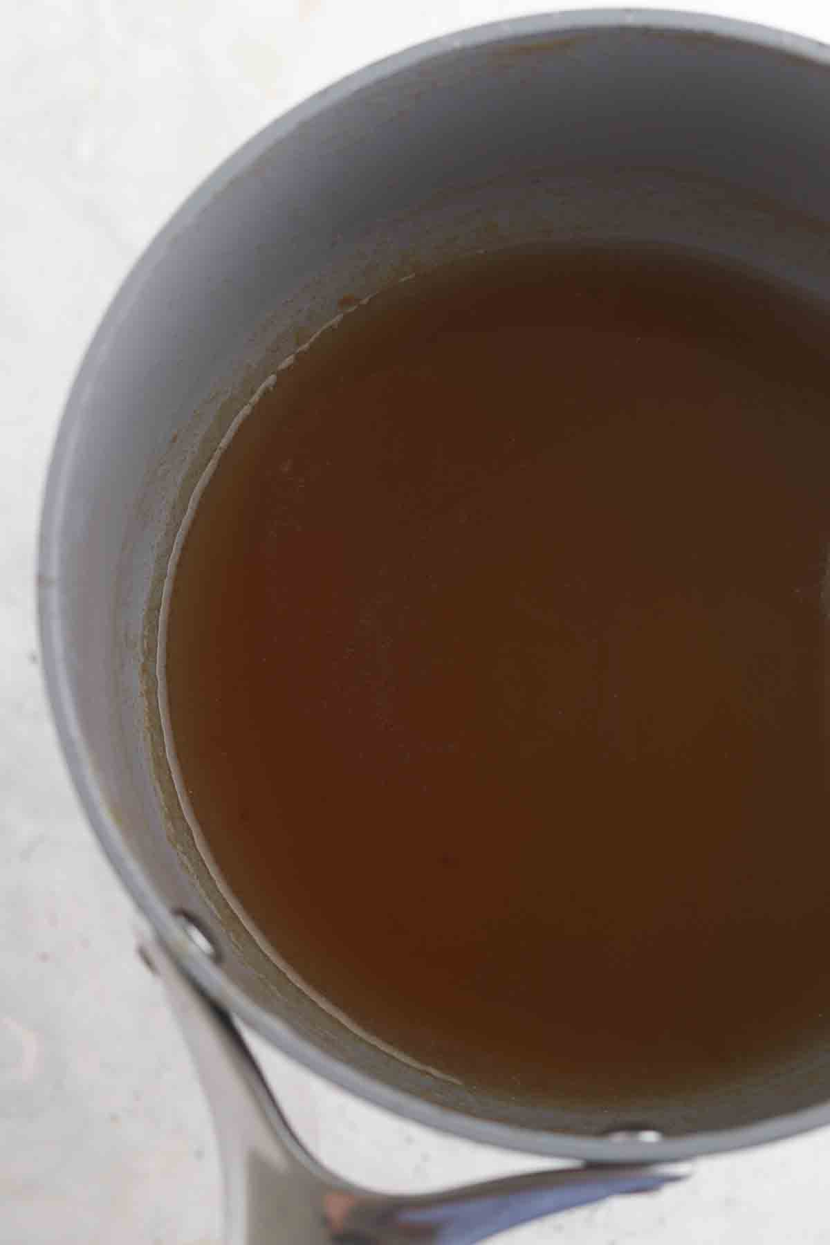 Water and honey in a sauce pot.