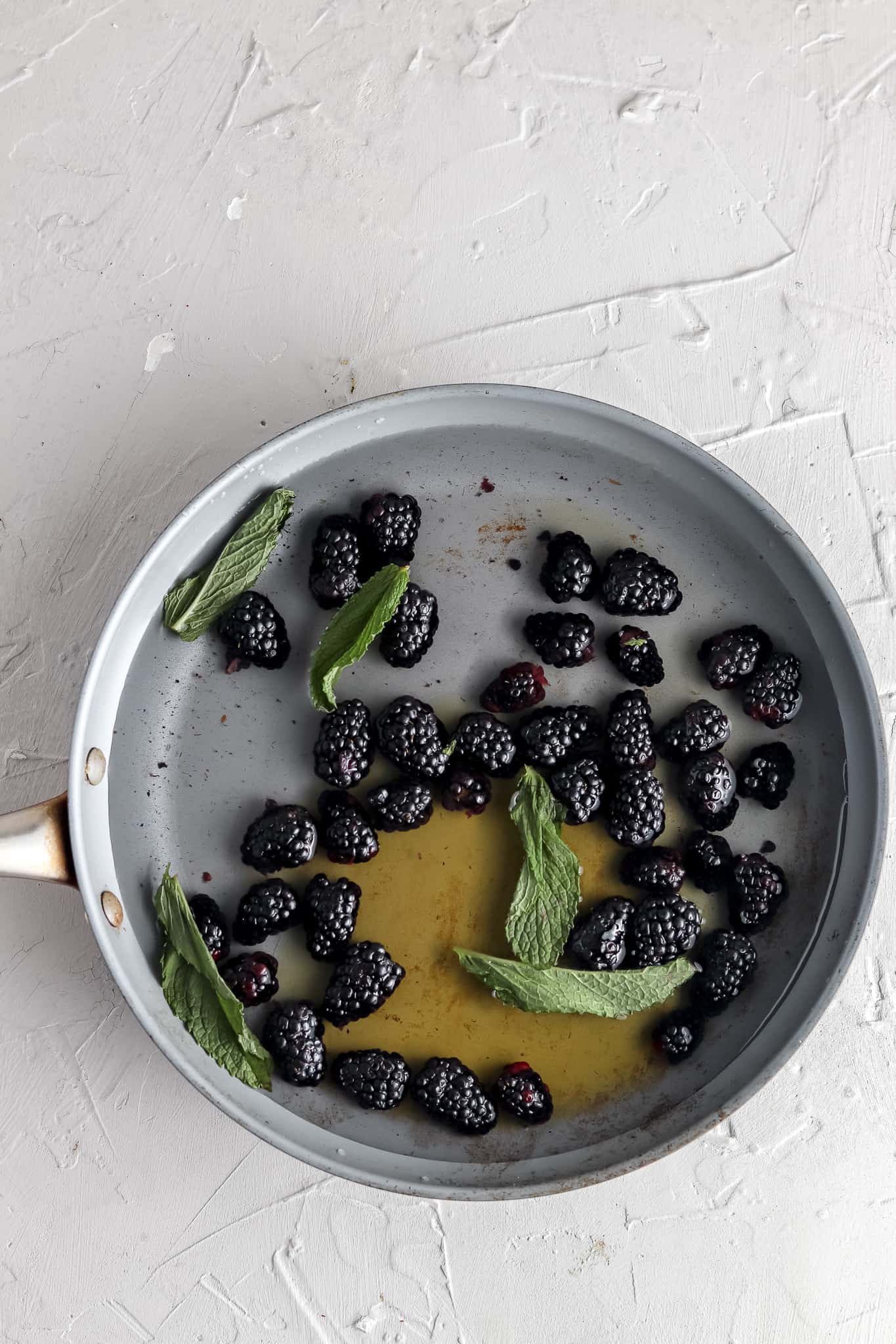 Blackberries, mint, honey and water in a pot.