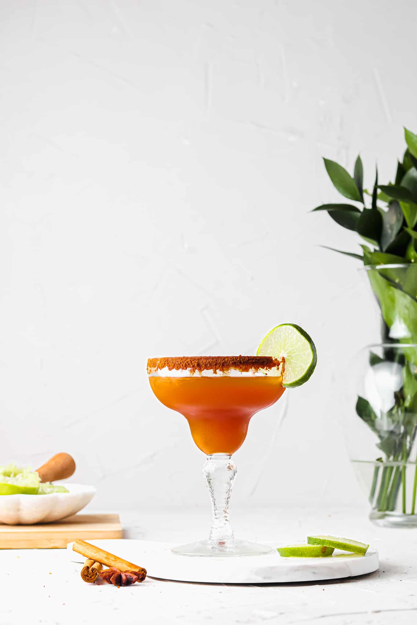 Zoomed out photo of an apple cider margarita mocktail with coconut sugar on the rim. 