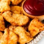 chicken nuggets on a plate with ketchup