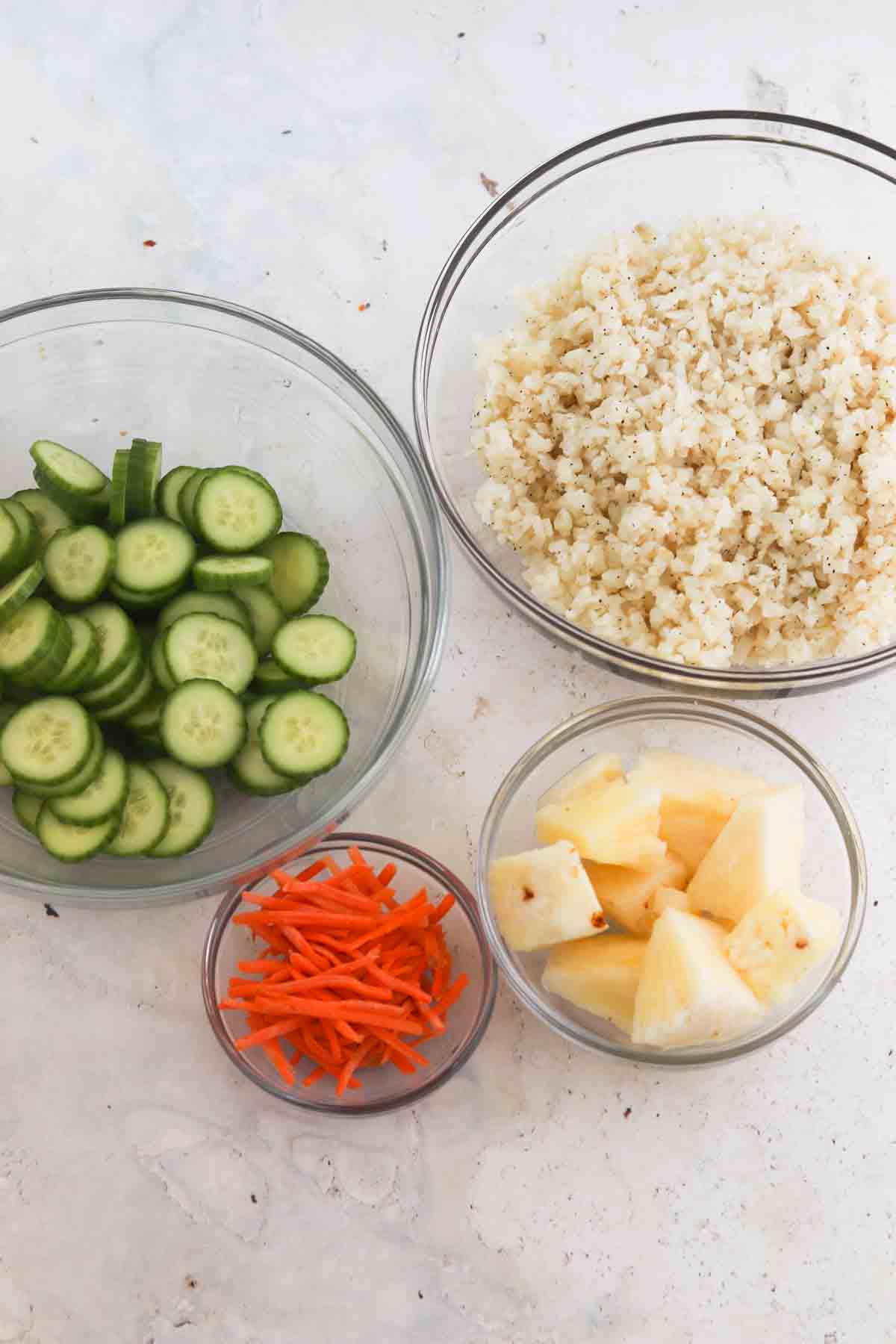 Rice, cauliflower, pineapple and carrots in a small bowl.