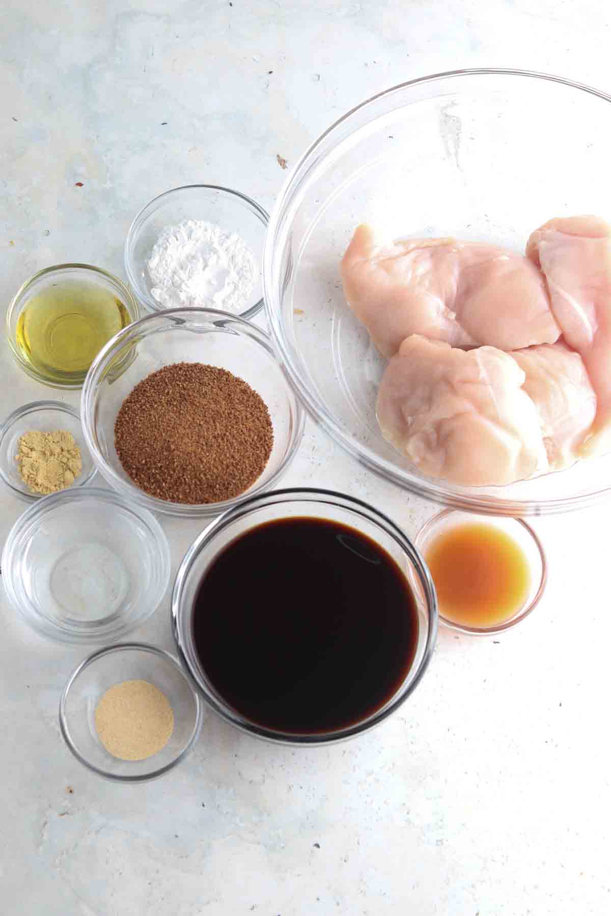 Chicken teriyaki ingredients laid out in small glass bowls on the counter. 