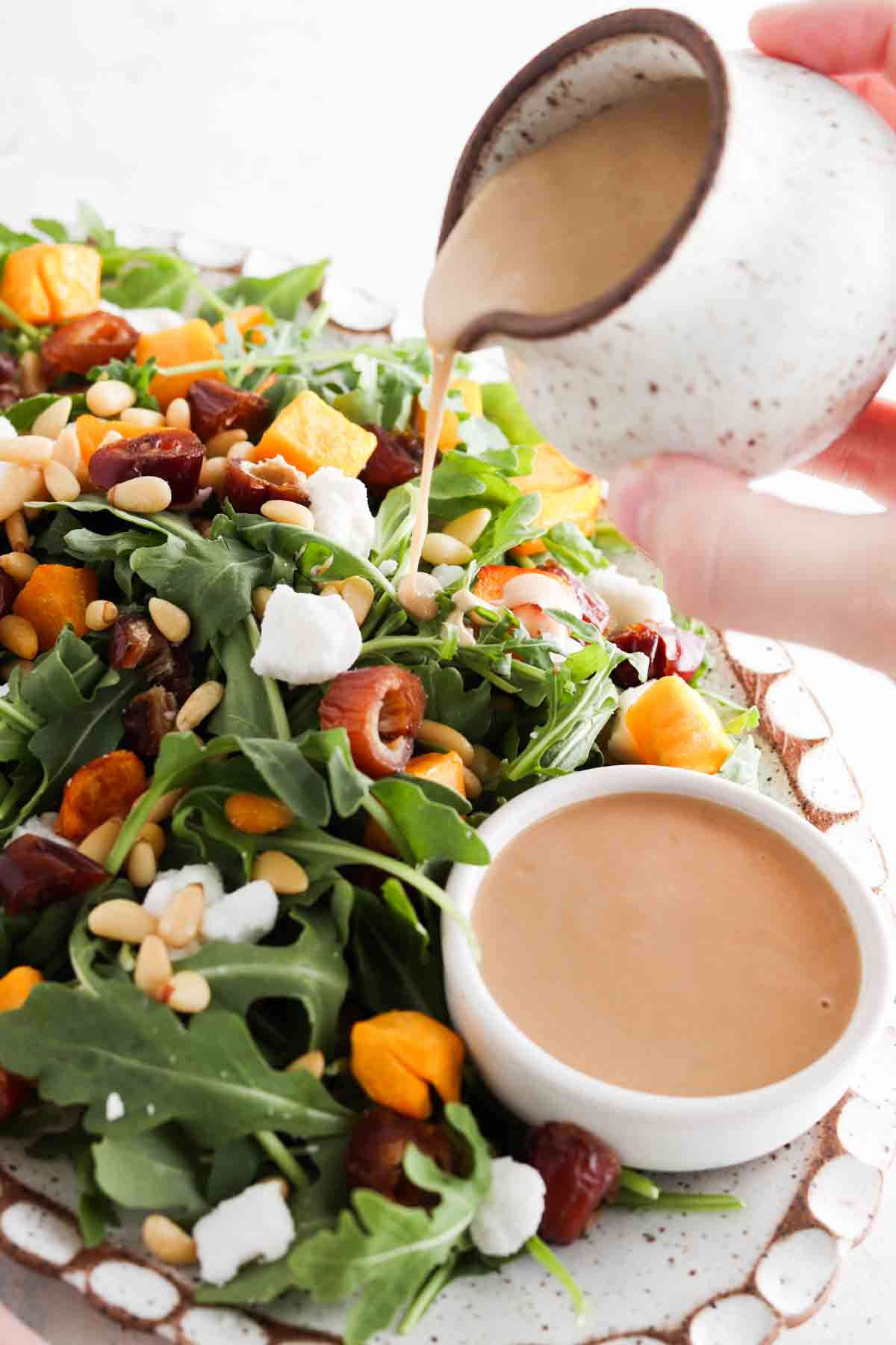 Arugula salad on a plate with dressing on top.