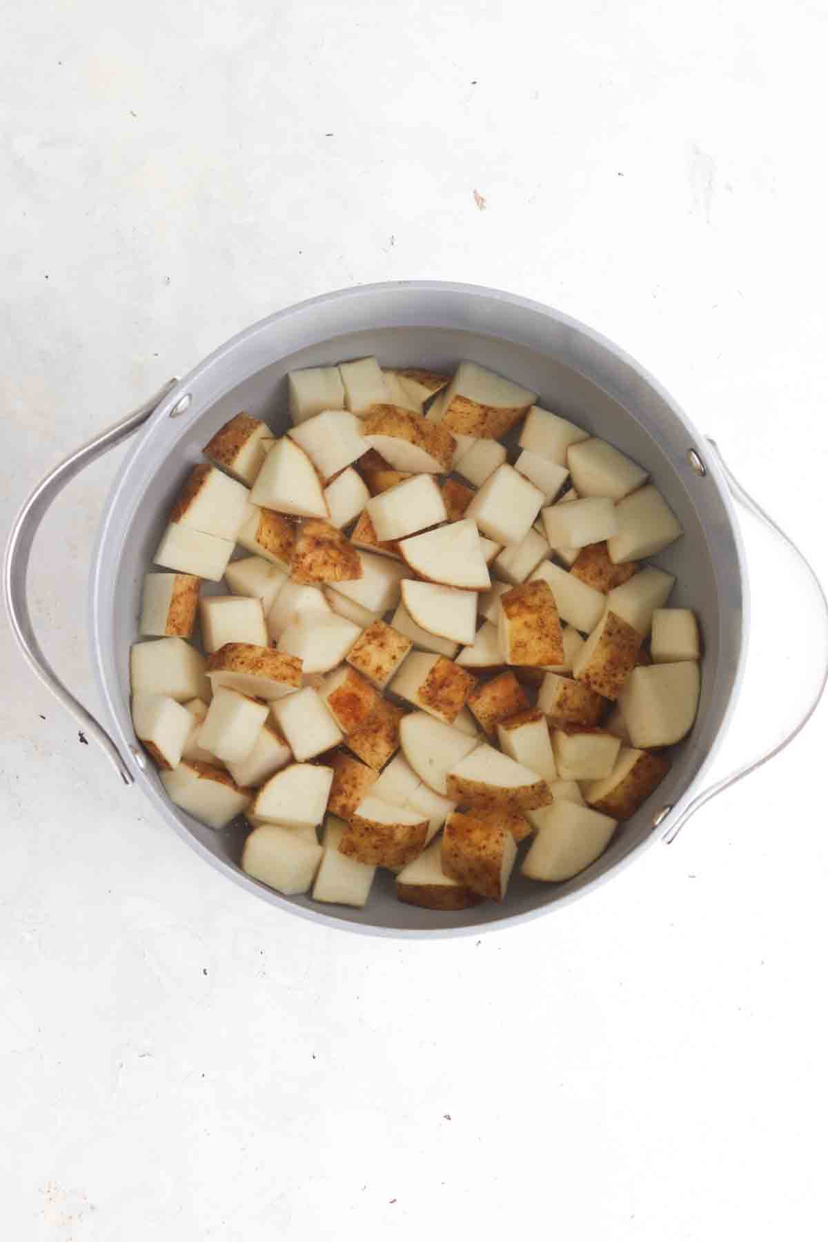 Cubed potatoes in a large pot of water.