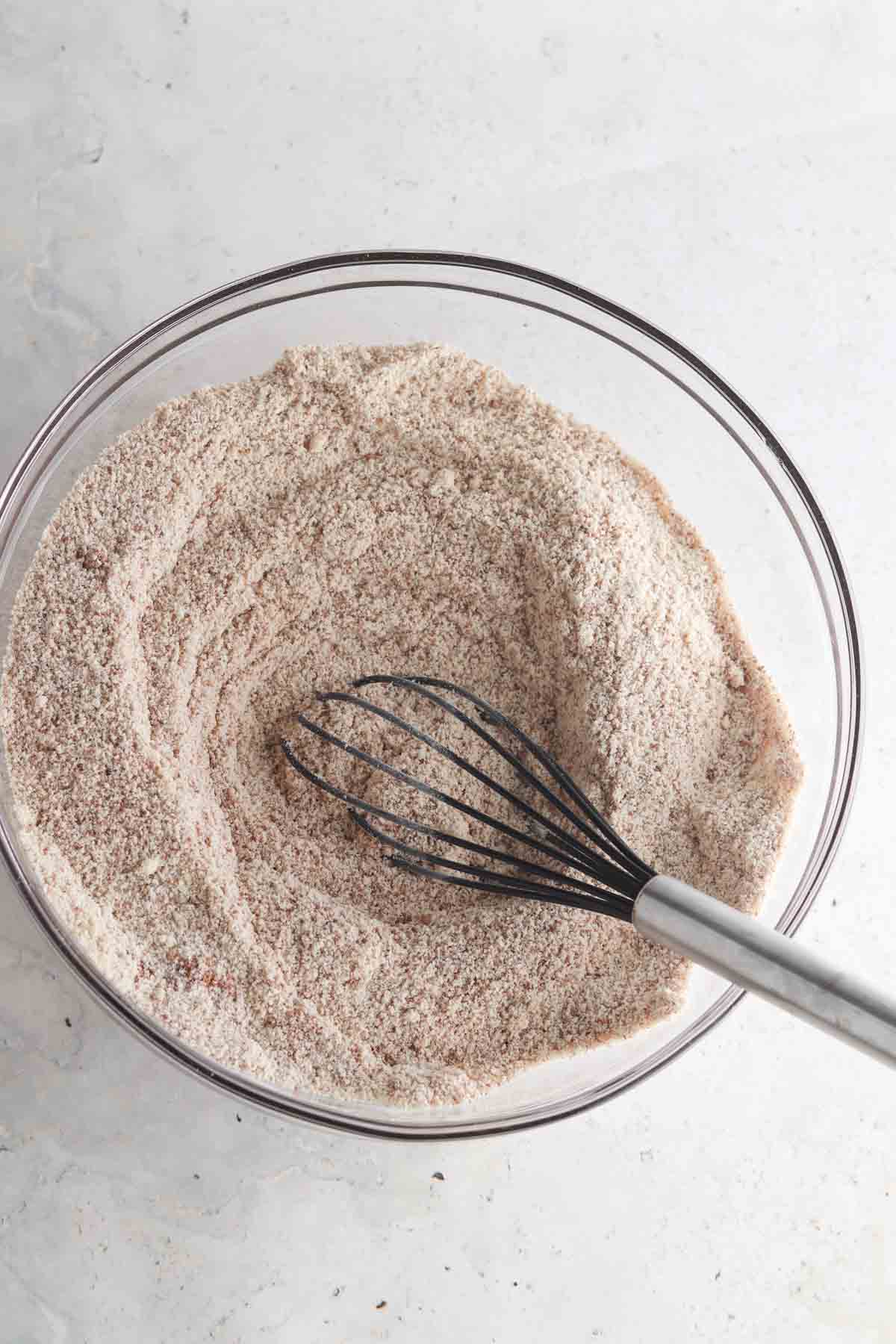 Red velvet cake dry ingredients in a bowl with a whisk.