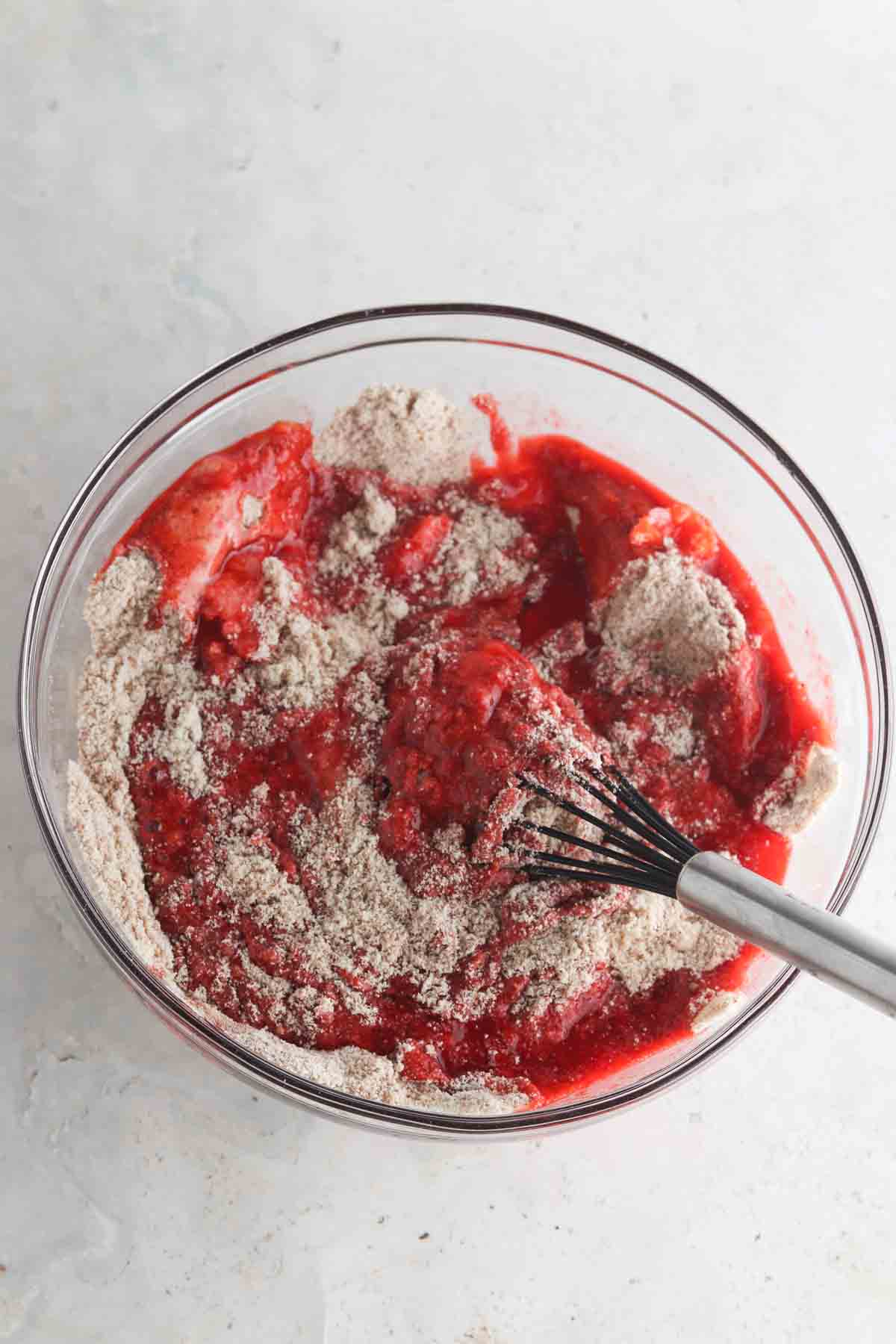 Bowl of the wet and dry cake ingredients being mixed together. 