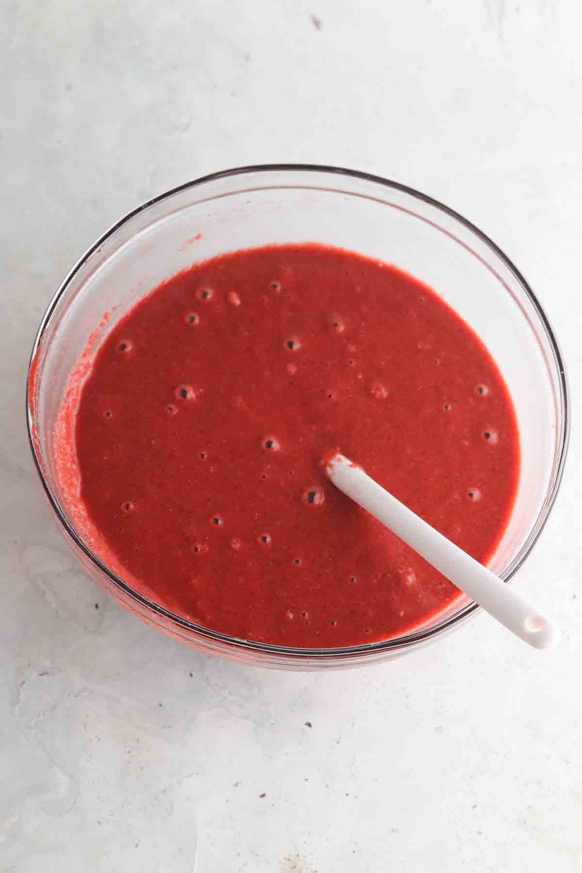 Red velvet cake wet ingredients in a large glass bowl. 