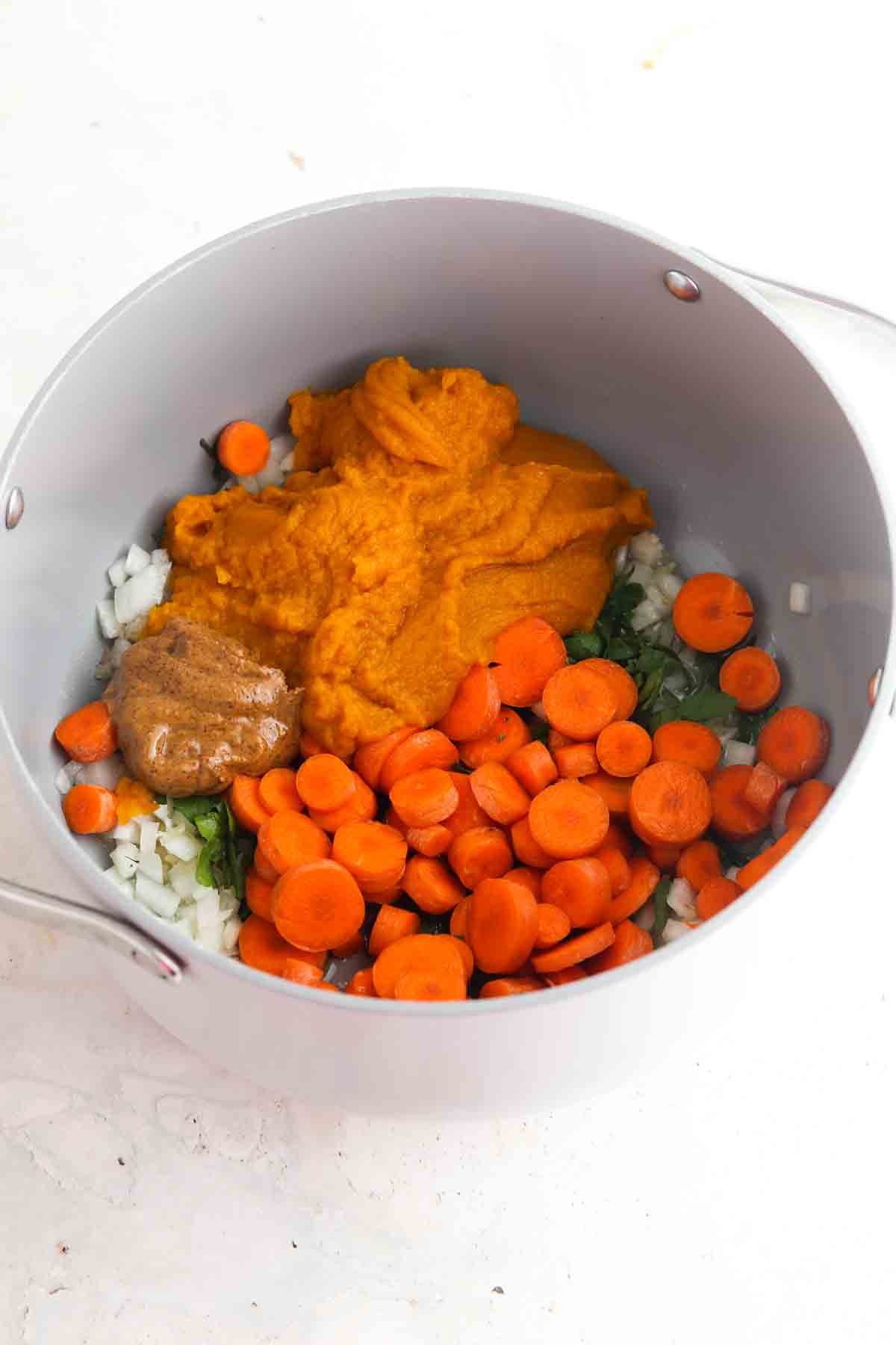 Carrots, pumpkin, onions, garlic and almond butter in a dutch oven.