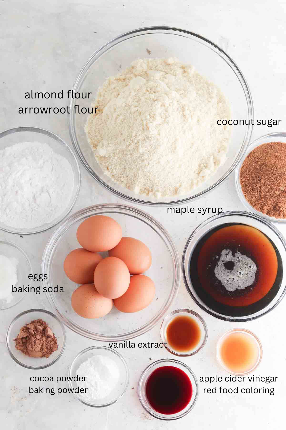 Red velvet cake ingredients laid out in small glass bowls. 