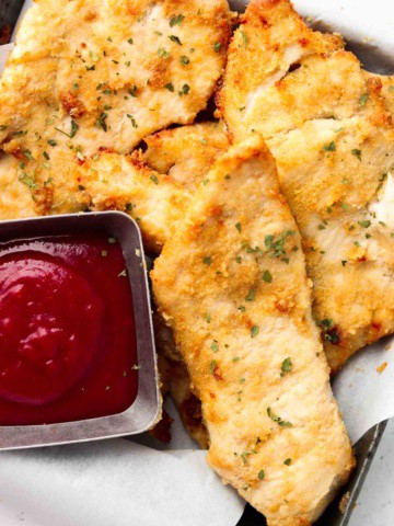 chicken tenders in a basket with ketchup