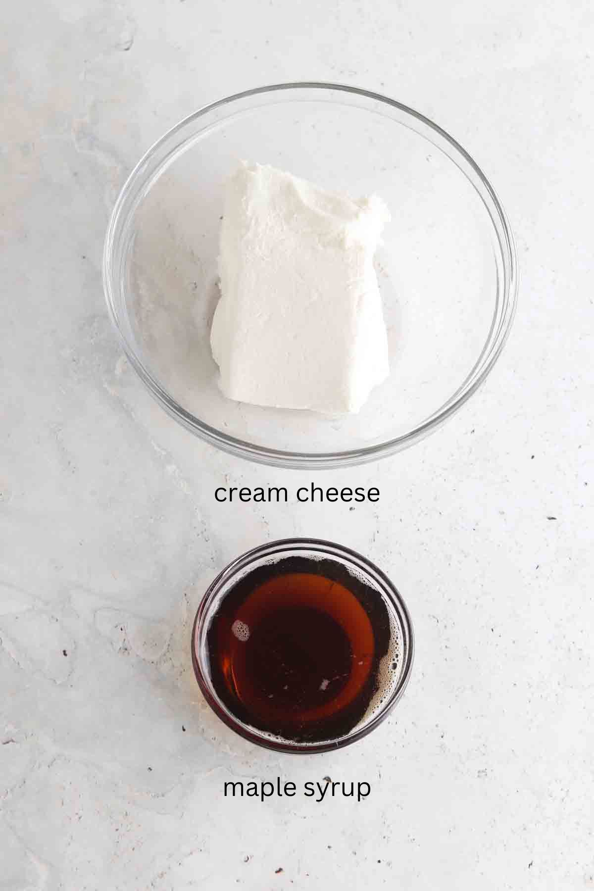 Frosting cake ingredients laid out in small glass bowls on the counter. 