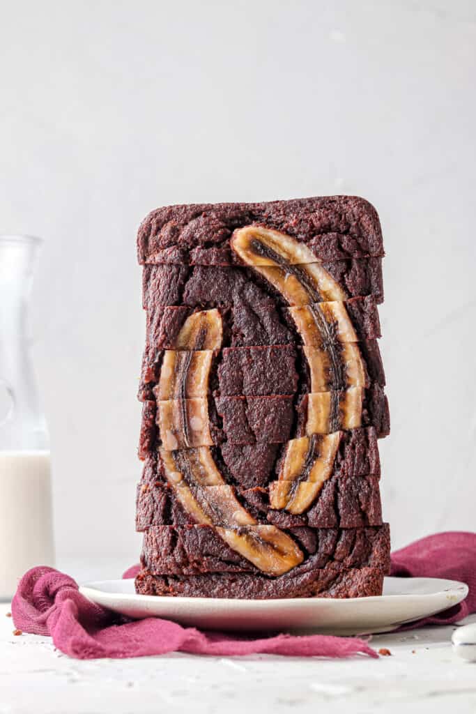 whole chocolate banana bread stacked on a white plate