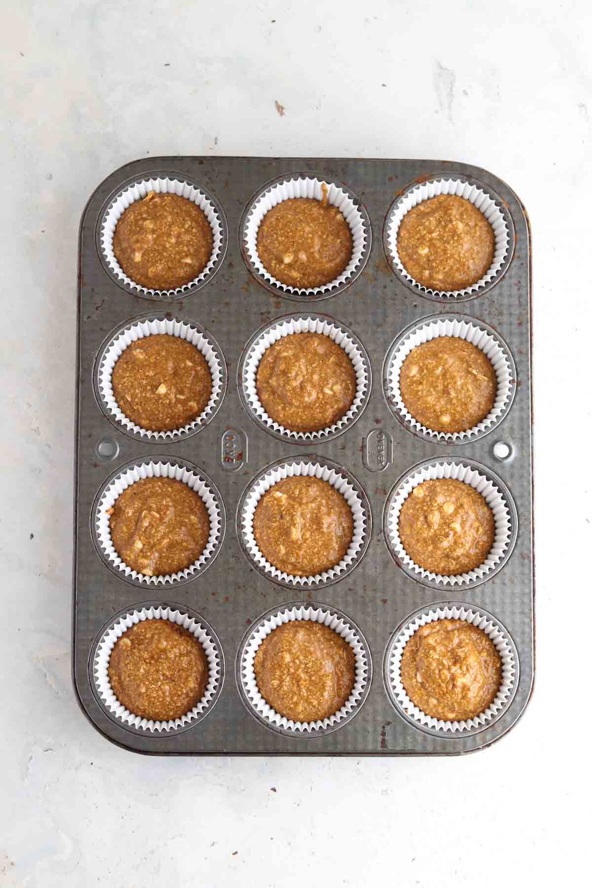 Oat flour pumpkin muffins in a muffin pan. 