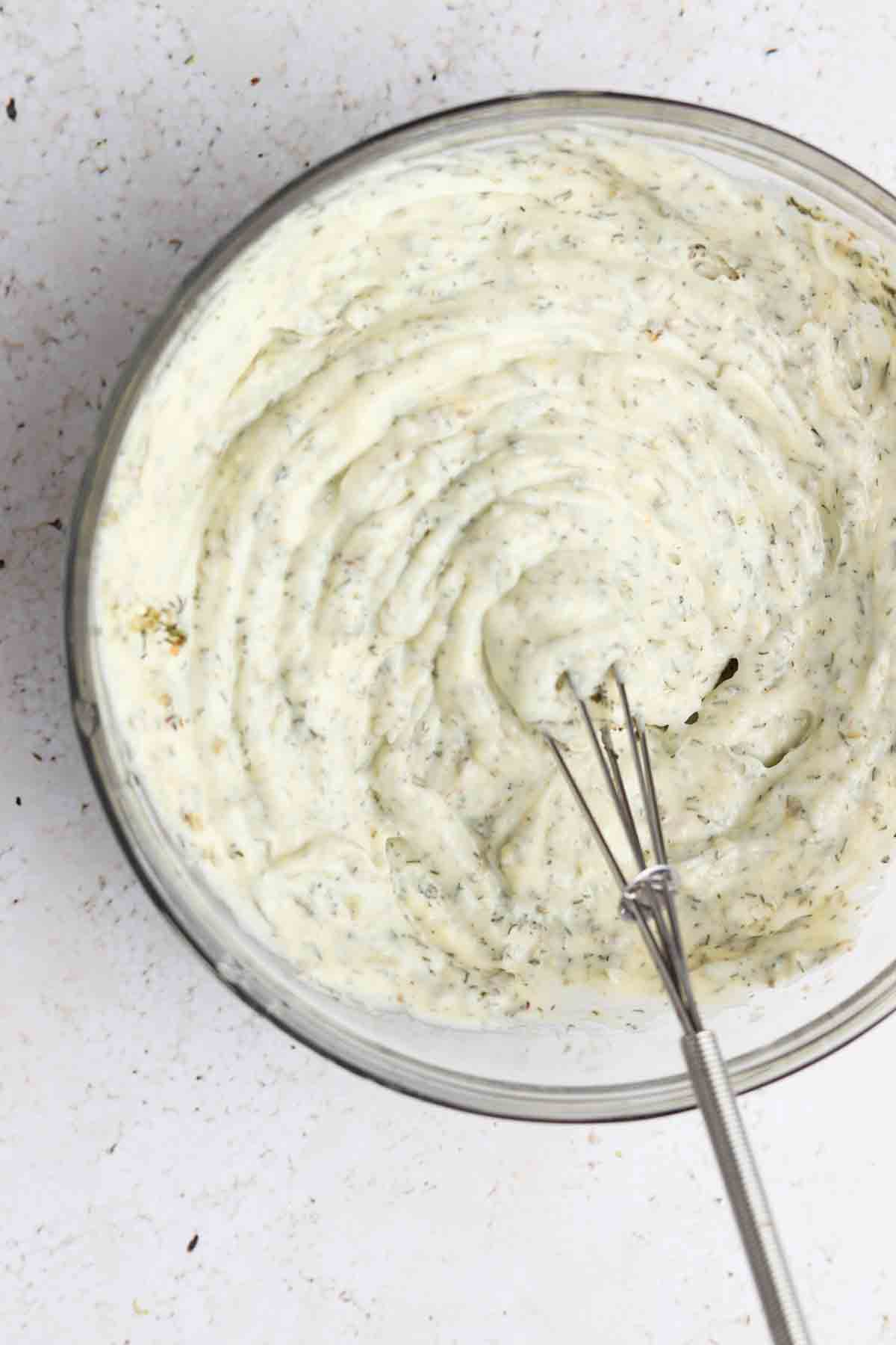 whole30 ranch in a glass mixing bowl with a small whisk