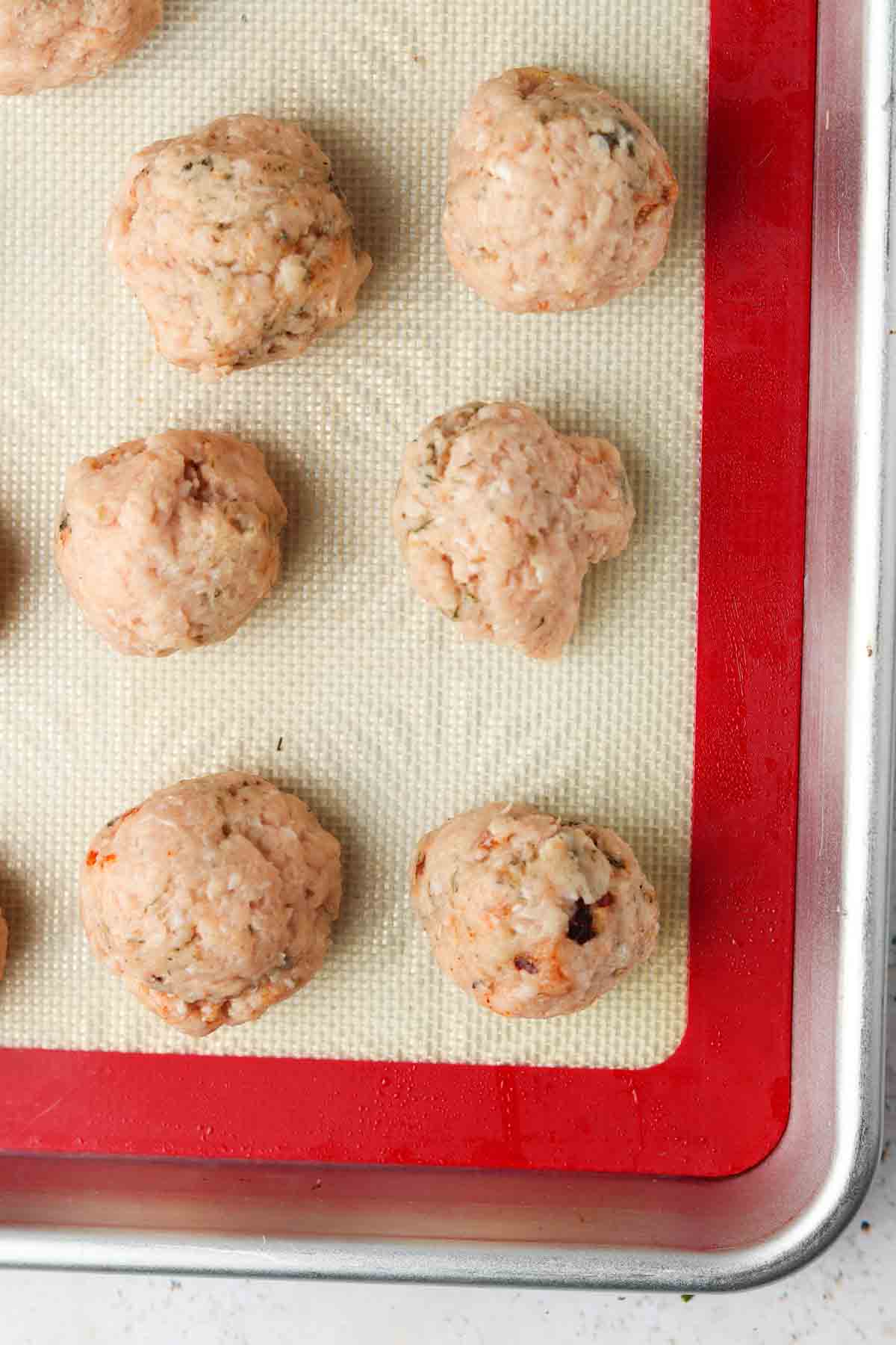 raw meatballs on a baking tray