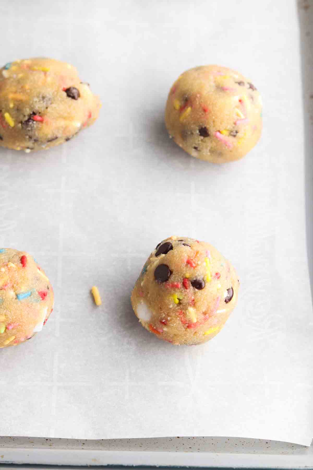 Cookie dough balls scooped on a baking sheet.