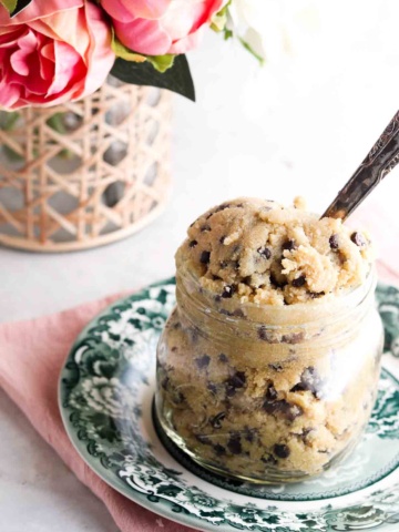 Cookie dough in a mason jar with a large spoon.