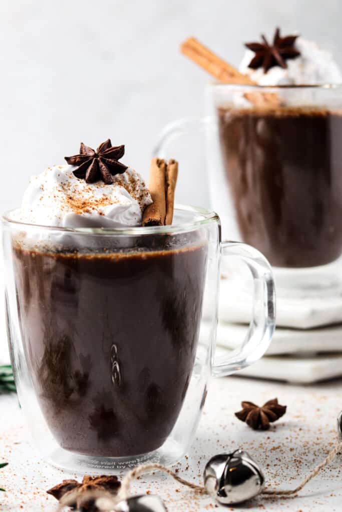 stack of aip hot chocolate in two clear coffee mugs