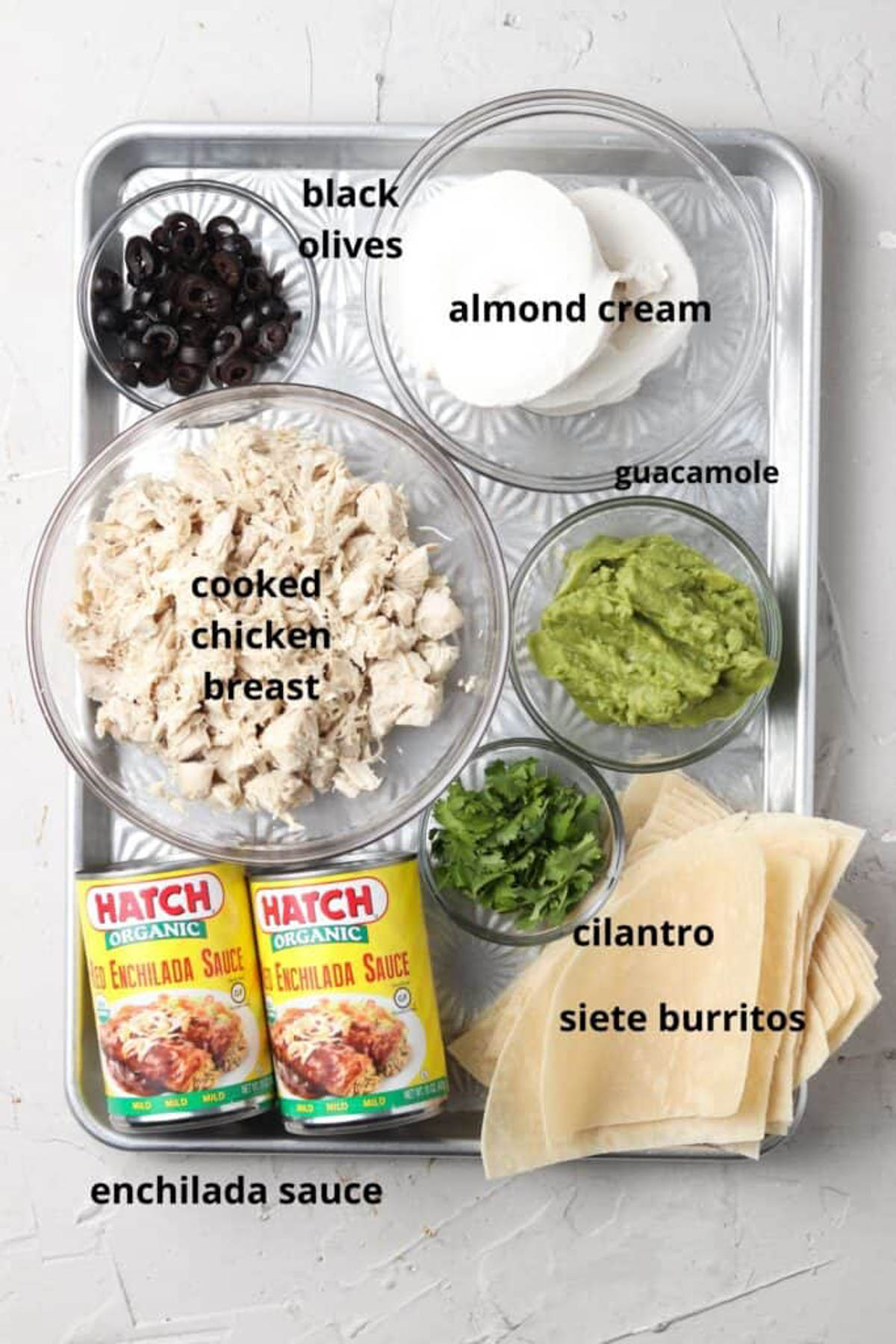 Dairy free enchilada ingredients in small glass bowls on a silver tray.