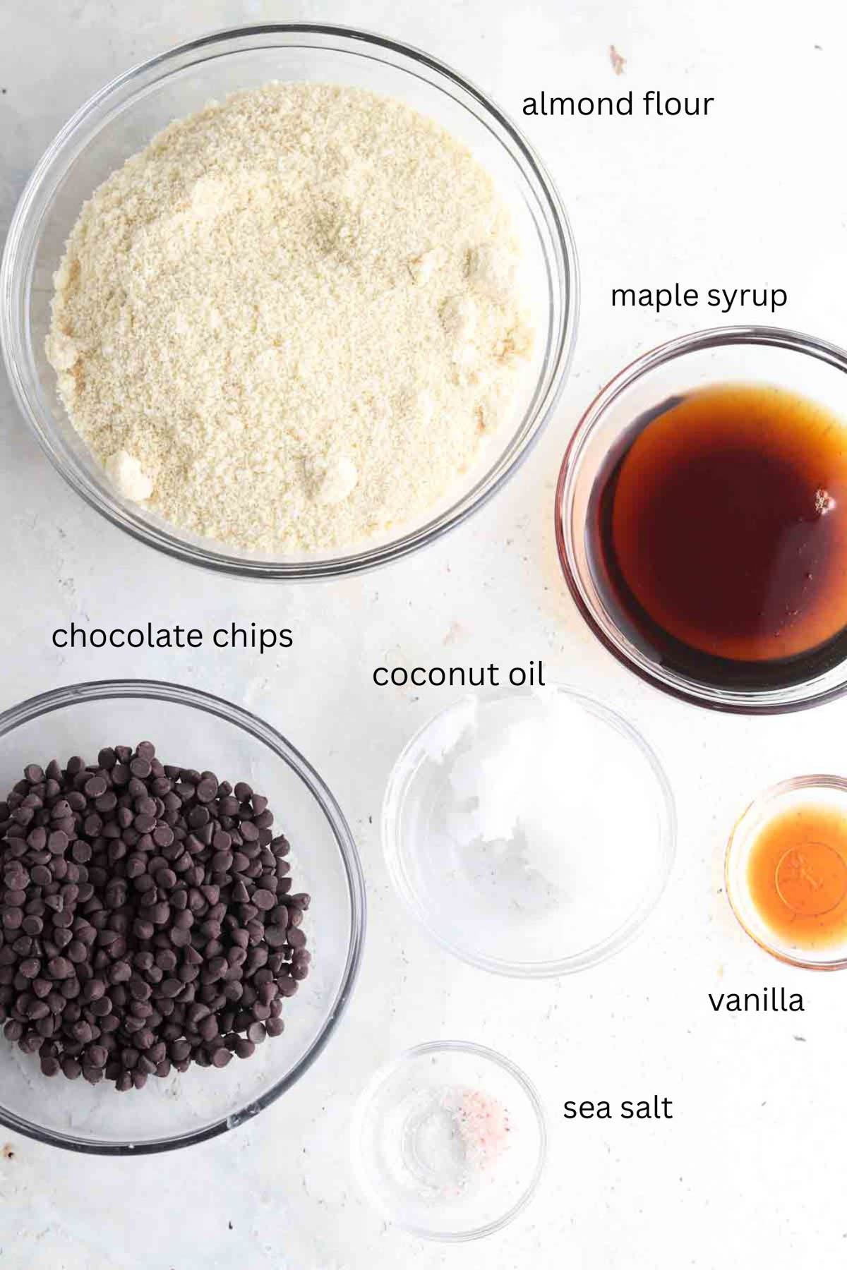 Cookie dough ingredients laid out in small glass bowls on the counter. 