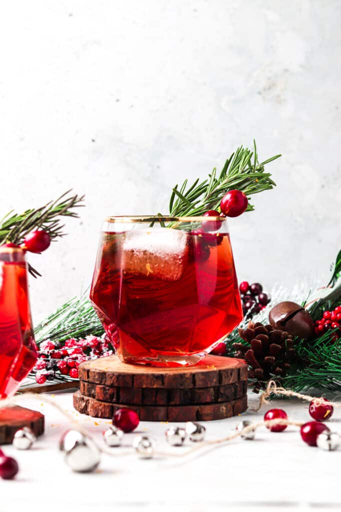 cranberry mocktail on 3 wooden coasters in a christmas setting