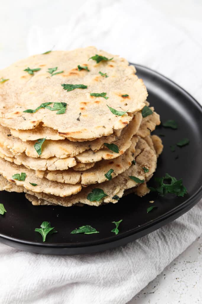 aip tortillas on a black plate with fresh herbs