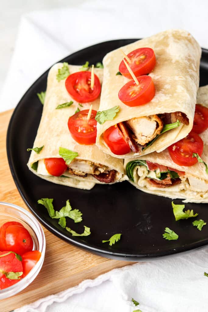 crispy ranch wraps on a black black with tomatoes