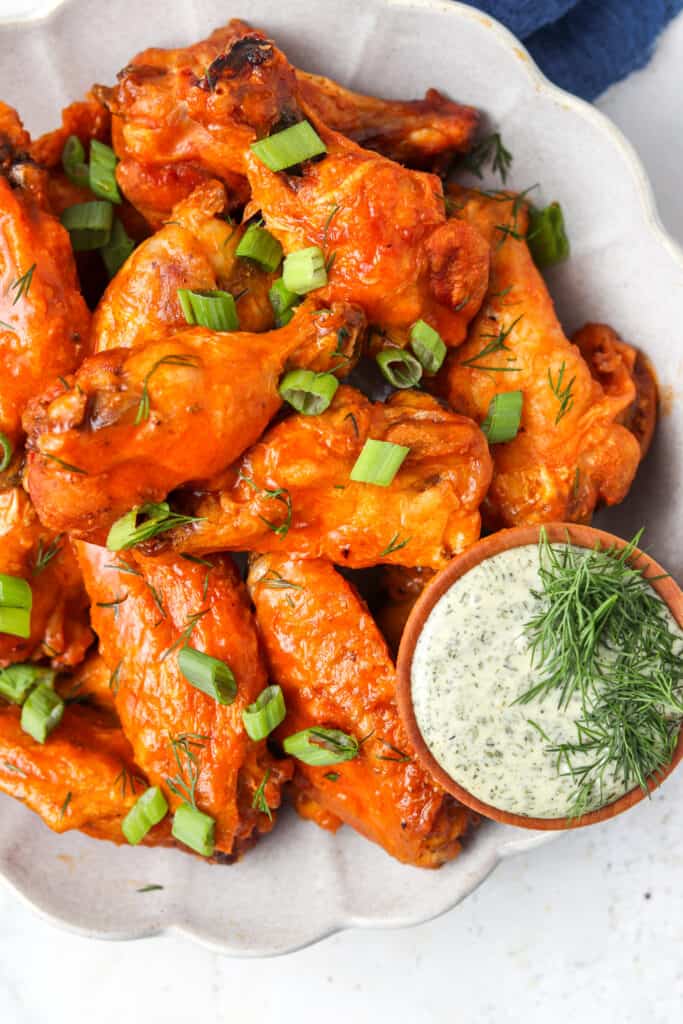 crispy buffalo chicken wings on a plate with ranch dressing