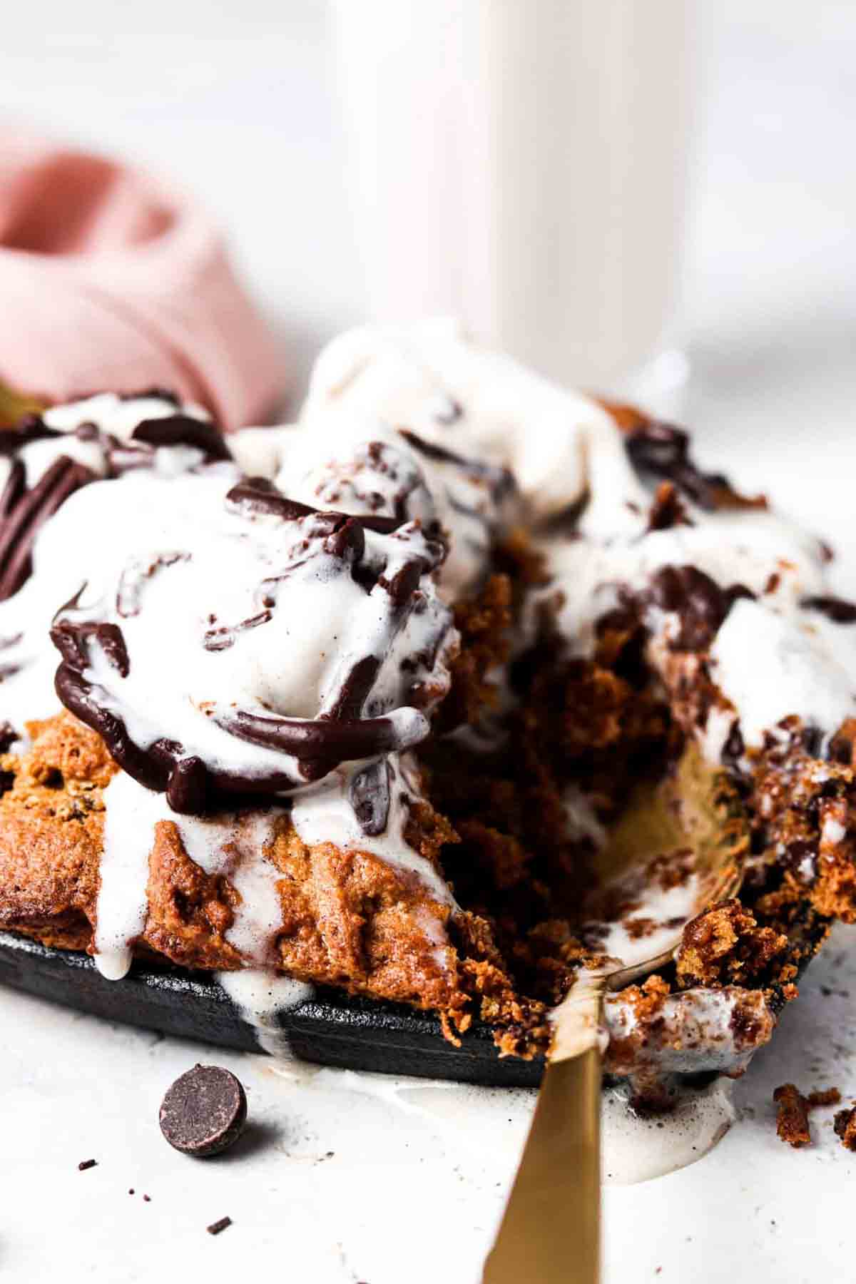 Mini cookie skillet with ice cream and chocolate on top.