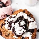 Chocolate chip cookie in a heart shape skillet with ice cream on top.
