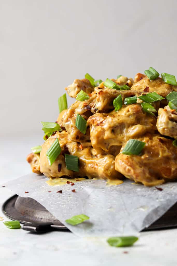 far away shot of honey mustard wings on a metal tray