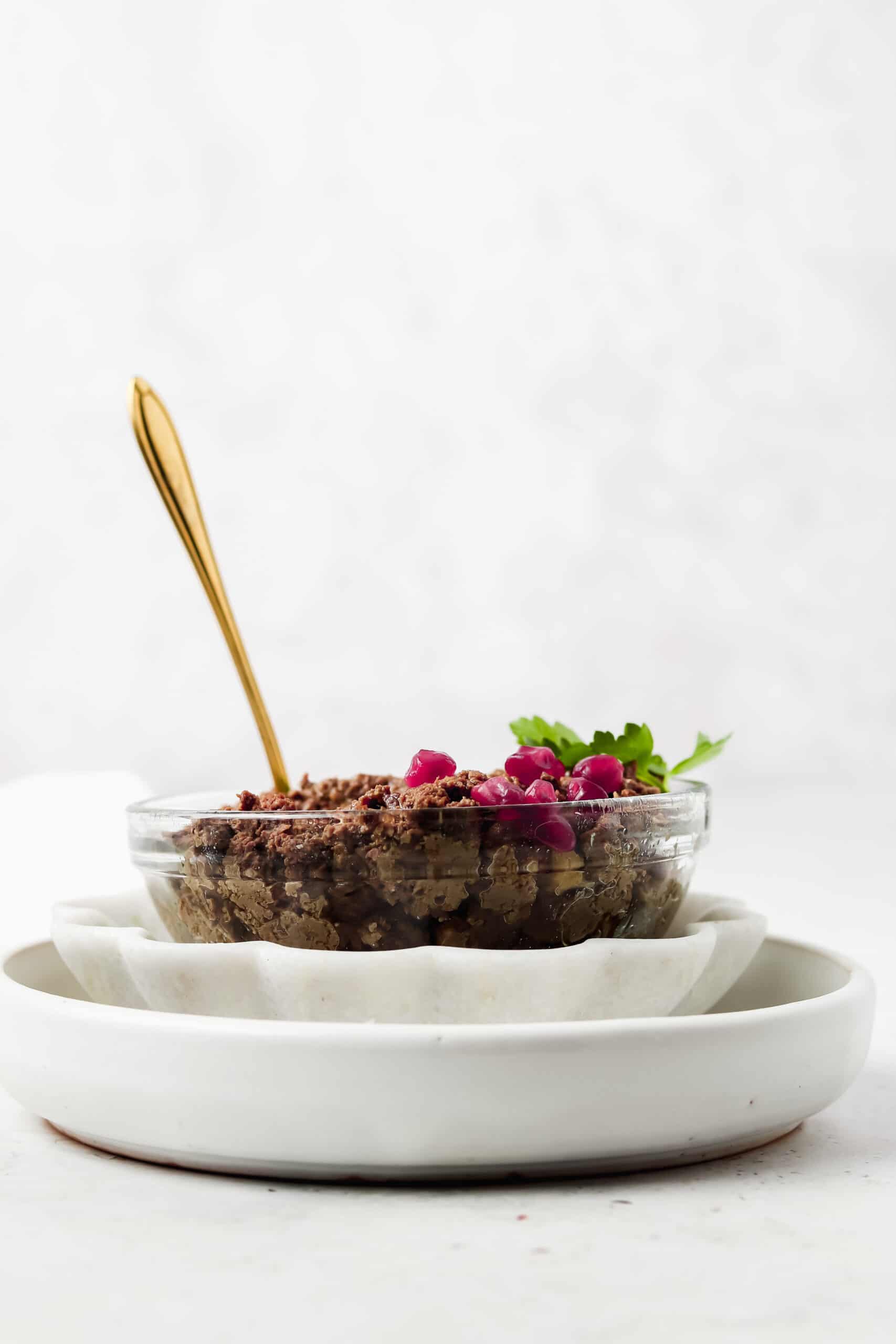 Beef liver pate in a bowl with a spoon hanging out of it.