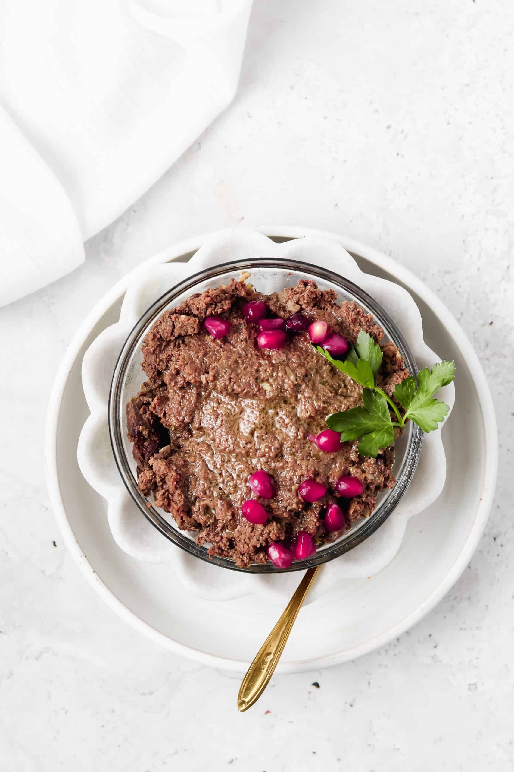 Beef liver pate in a white bowl with a spoon.